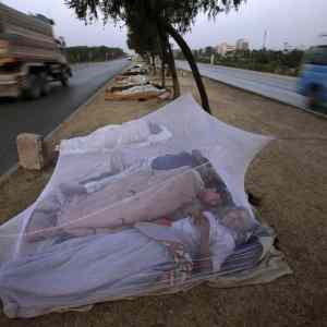 Obrázek 'Foto tyzdna - Pakistan - Robotnici spia pri ceste na predmesti'
