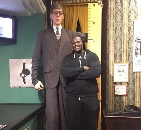 Obrázek Shaq next to a replica of the tallest man to have lived